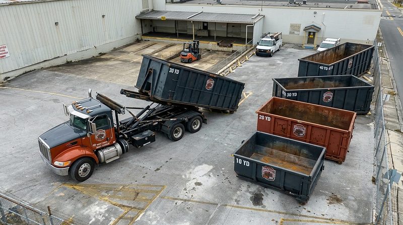 BrickCity Roll Off containers and a roll-off truck in the company yard